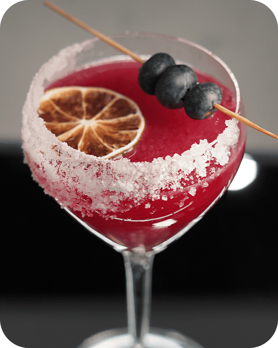 Cocktail with blueberries and lemon slice, perfect for spirits and dining.