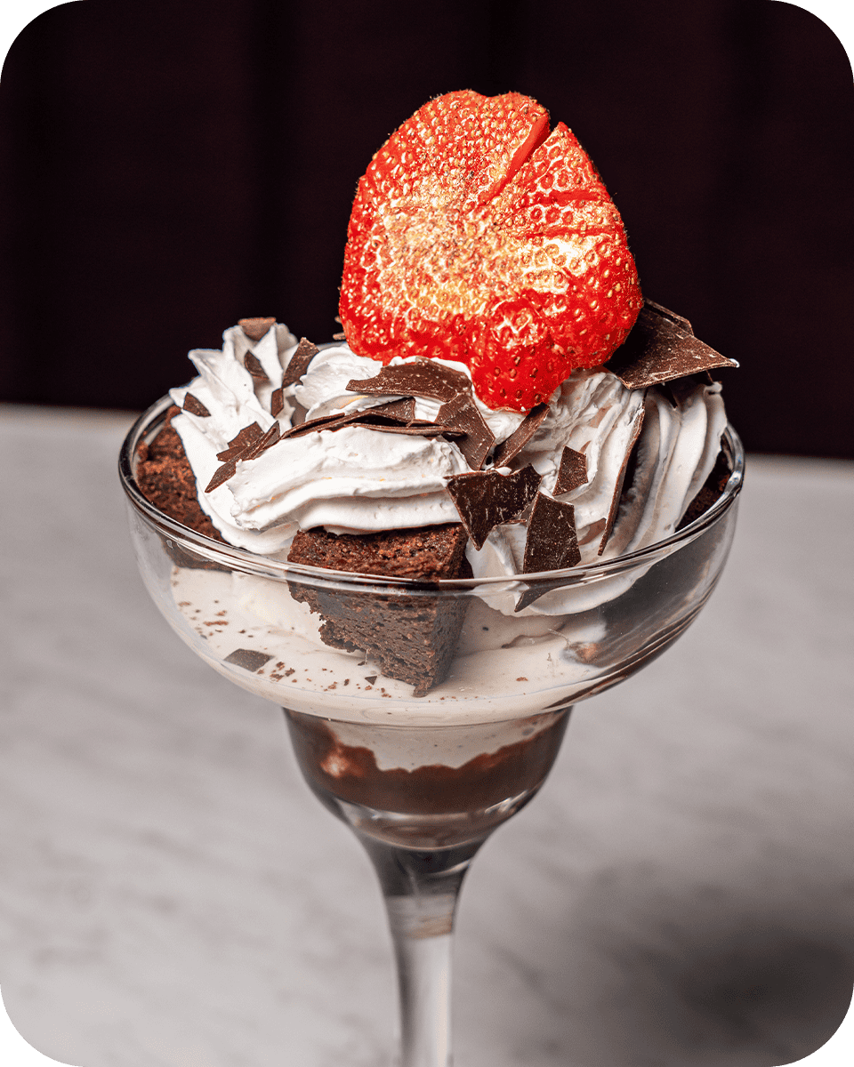 Delicious strawberry and chocolate dessert served in a glass, perfect for spirits and dining experie.