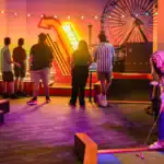 Family enjoying mini-golf during a lively celebration at Albatross. Perfect for memorable events and.