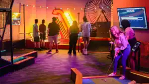 Family enjoying mini-golf during a lively celebration at Albatross. Perfect for memorable events and.