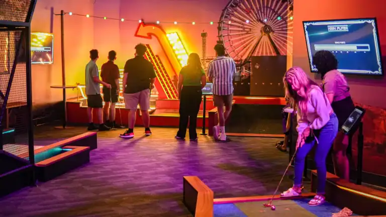 Family enjoying mini-golf during a lively celebration at Albatross. Perfect for memorable events and.